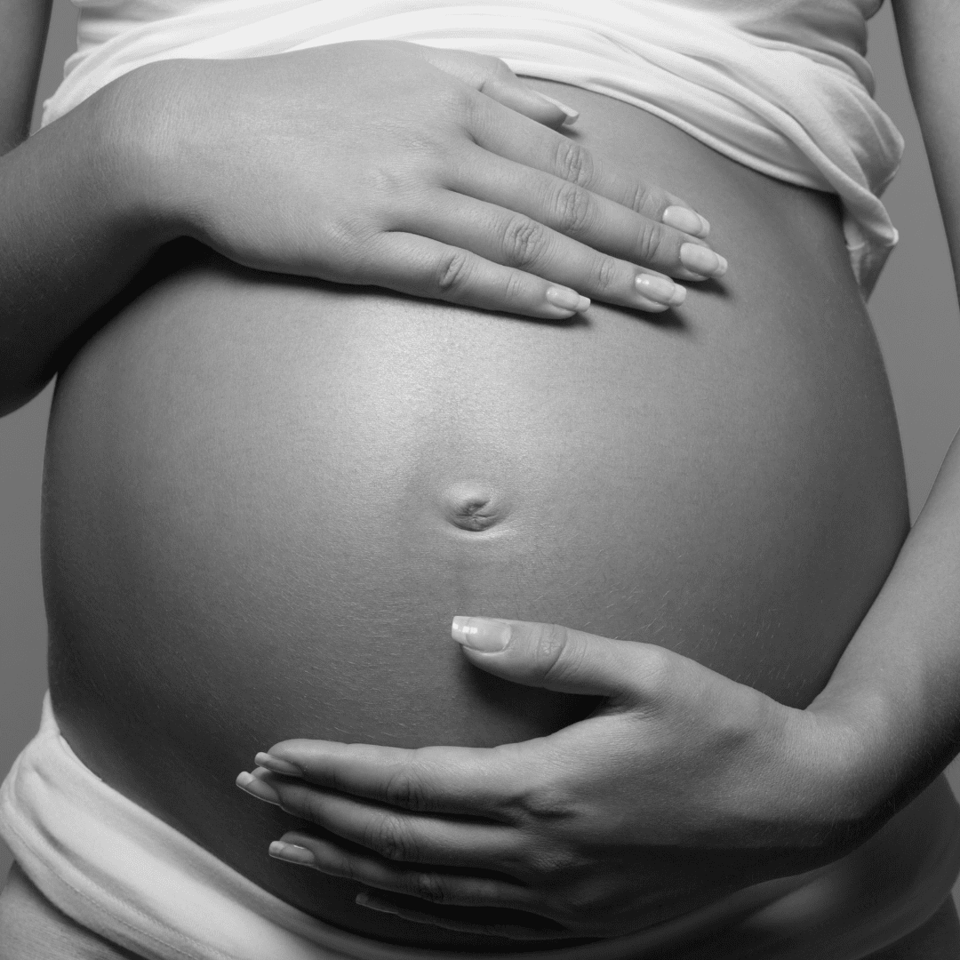 A pregnant woman is holding her belly