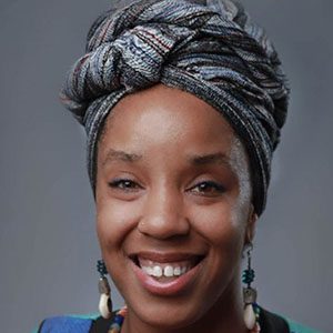 A smiling african woman wearing a turban.